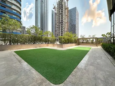 a green artificial lawn in the middle of a city at Trophy - Private Office Solace Suite in Dubai