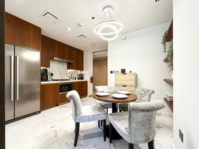 a kitchen with a table and chairs and a refrigerator at Trophy - Private Office Solace Suite in Dubai