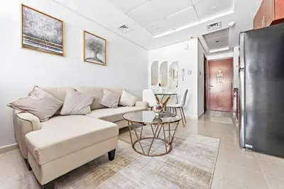 a living room with a couch and a table at StoneTree - Furnished Studio Near Metro in Dubai