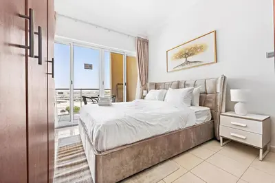 a bedroom with a bed and a large window at StoneTree - Furnished Studio Near Metro in Dubai