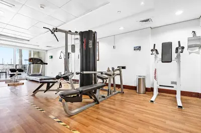 a gym with treadmills and machines in a room at StoneTree - Furnished Studio Near Metro in Dubai