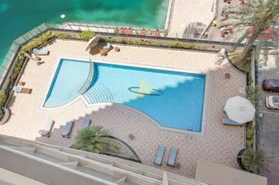 an overhead view of a swimming pool next to the water at StoneTree - Furnished Studio Near Metro in Dubai