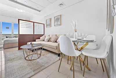 a living room with a couch and a table at StoneTree - Furnished Studio Near Metro in Dubai