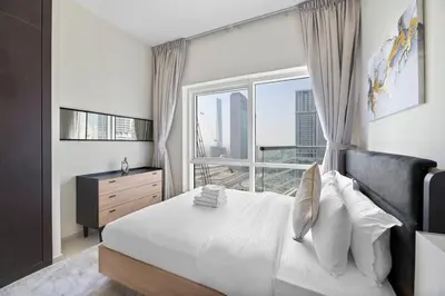 a bedroom with a bed and a large window at StoneTree - Elegant 1 BR with Amazing View in Dubai