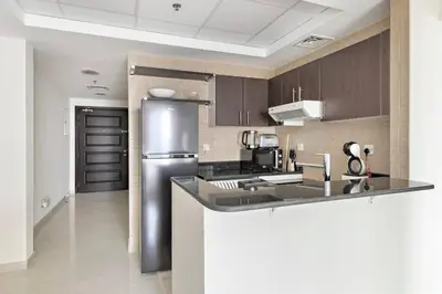 a kitchen with a stainless steel refrigerator at StoneTree - Elegant 1 BR with Amazing View in Dubai