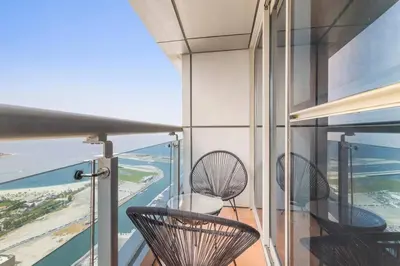 a balcony with two chairs and a view of the ocean at StoneTree - Sea View - High-Floor in Dubai