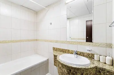 a white bathroom with a sink and a bath tub at StoneTree - Sea View - High-Floor in Dubai