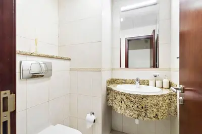 a white bathroom with a sink and a mirror at StoneTree - Sea View - High-Floor in Dubai