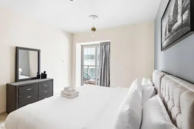 a white bedroom with a large bed and a mirror at StoneTree - Sea View - High-Floor in Dubai