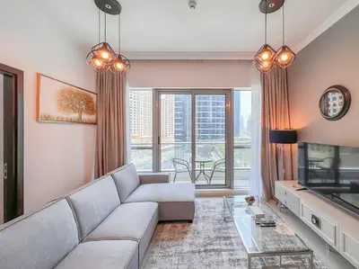 a living room with a couch and a tv at StoneTree - Furnished 1BR near Marina Walk in Dubai