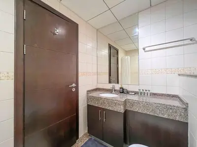 a bathroom with a sink and a brown door at StoneTree - Furnished 1BR near Marina Walk in Dubai