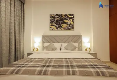 a bedroom with a large bed with two lamps at Stylish 2BR Suite Near MOE in Dubai