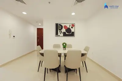 a white dining room with a table and chairs at Stylish 2BR Suite Near MOE in Dubai