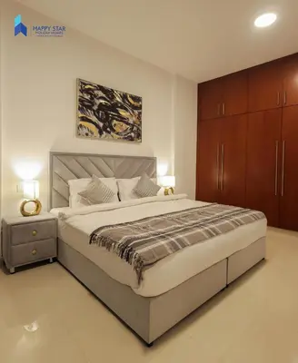 a bedroom with a large bed and a wooden cabinet at Stylish 2BR Suite Near MOE in Dubai