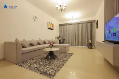 a living room with a couch and a tv at Stylish 2BR Suite Near MOE in Dubai