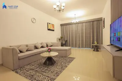 a living room with a couch and a tv at Stylish 2BR Suite Near MOE in Dubai