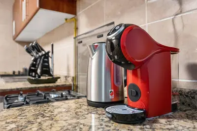 a red and silver appliance sitting on a kitchen counter at StoneTree - Homelike 1BR in Dubai Marina in Dubai