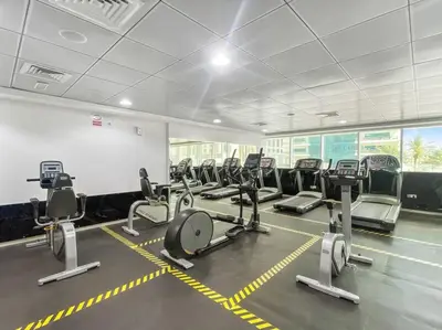 a gym with several rows of cardio machines at StoneTree - Homelike 1BR in Dubai Marina in Dubai