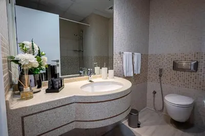 a bathroom with a sink and a toilet and a mirror at Daniels Spacious 1BR in Heart of Dubai Marina in Dubai