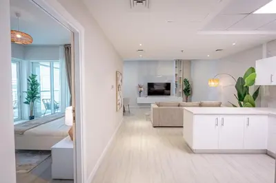 a white living room with a bed and a couch at Daniels Spacious 1BR in Heart of Dubai Marina in Dubai