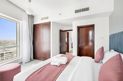 a bedroom with a large bed and a large window at StoneTree - Stylish 1BR in JLT in Dubai