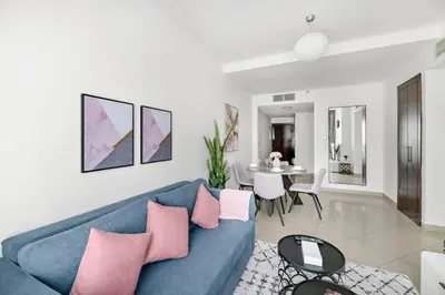 a living room with a blue couch and a table at StoneTree - Stylish 1BR in JLT in Dubai
