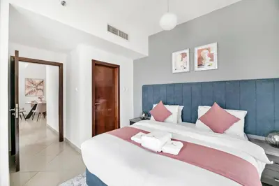 a bedroom with a large bed with a blue headboard at StoneTree - Stylish 1BR in JLT in Dubai