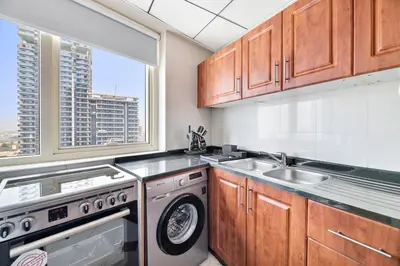 a kitchen with a washing machine and a sink at StoneTree - Stylish 1BR in JLT in Dubai