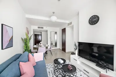 a living room with a blue couch and a tv at StoneTree - Stylish 1BR in JLT in Dubai