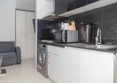 a kitchen with a microwave and a washing machine at StoneTree - Cozy Studio Apartment in Business Bay in Dubai