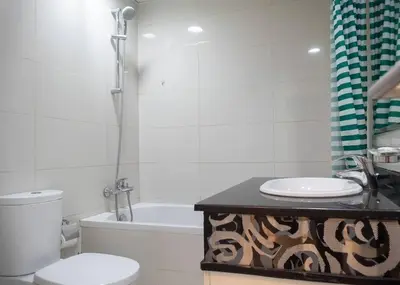 a bathroom with a toilet and a sink and a tub at StoneTree - Cozy Studio Apartment in Business Bay in Dubai