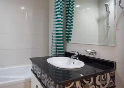 a bathroom with a sink and a mirror and a tub at StoneTree - Cozy Studio Apartment in Business Bay in Dubai