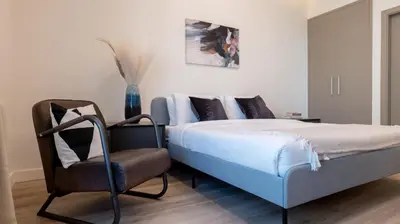 a bedroom with a bed and a chair at Classy 1 BR Apartment in Greens in Dubai