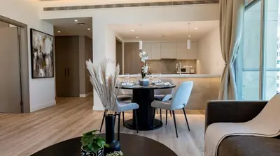 a living room and kitchen with a table and chairs at Classy 1 BR Apartment in Greens in Dubai