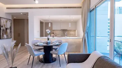 a dining room and kitchen with a table and chairs at Classy 1 BR Apartment in Greens in Dubai