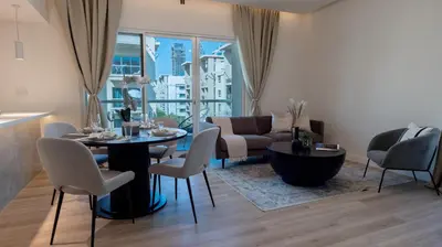 a living room with a table and chairs and a couch at Classy 1 BR Apartment in Greens in Dubai