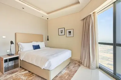 a bedroom with a bed and a large window at ALiving Supreme 3BR I Paramount Towers, Business Bay- 6104 in Dubai