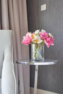 a vase of flowers sitting on a table at ALiving Supreme 3BR I Paramount Towers, Business Bay- 6104 in Dubai