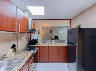 a kitchen with a black refrigerator and a sink at StoneTree - Modern 1 BR Apartment Near The Beach in Dubai