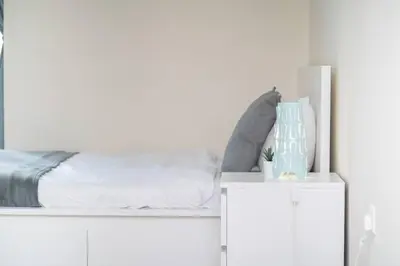 a white bedroom with a bed on a white cabinet at StoneTree - Chic Studio in Jumeirah Lake Towers in Dubai