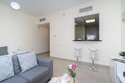 a living room with a couch and a table at StoneTree - Chic Studio in Jumeirah Lake Towers in Dubai