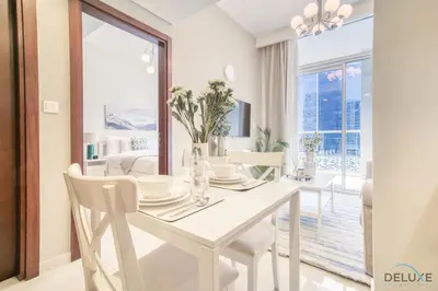 a white dining room with a white table and chairs at Contemporary 1BR at Vera Tower Business Bay by Deluxe Holiday Homes in Dubai