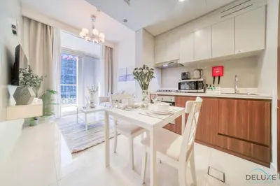 a kitchen and dining room with a white table and chairs at Contemporary 1BR at Vera Tower Business Bay by Deluxe Holiday Homes in Dubai