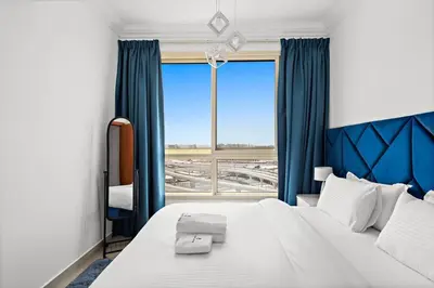 a bedroom with a large bed and a large window at StoneTree - Stylish 1BR near Marina Walk in Dubai