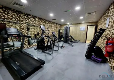 a gym with treadmills and cardio equipment in a room at Ritzy 1BR at Global Golf Residence 2 Sports City by Deluxe Holiday Homes in Dubai