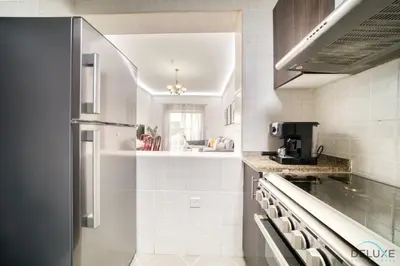 a kitchen with a refrigerator and a counter top at Ritzy 1BR at Global Golf Residence 2 Sports City by Deluxe Holiday Homes in Dubai