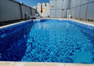 a swimming pool with blue water in a building at Ritzy 1BR at Global Golf Residence 2 Sports City by Deluxe Holiday Homes in Dubai