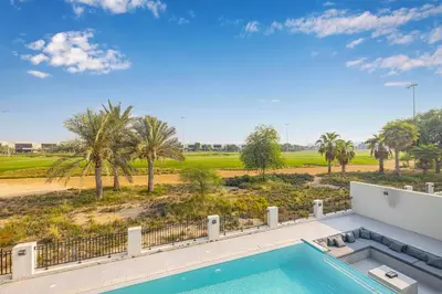 a swimming pool with a view of a golf course at Daniels 5BR Villa with Private Pool at Damac Hills in Dubai