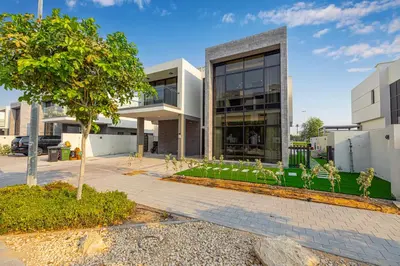 a building with a tree in front of it at Daniels 5BR Villa with Private Pool at Damac Hills in Dubai