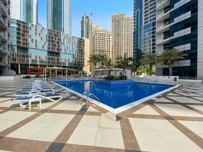 a swimming pool with lounge chairs in a city at StoneTree - Furnished 1 BR in Bay Central in Dubai